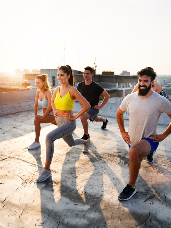Group of young friends exercising together on the concrete rooftop