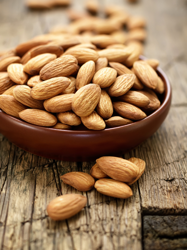 A bowl of almonds on a wooden table