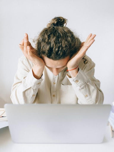 Woman tired from work holding her head with both hands