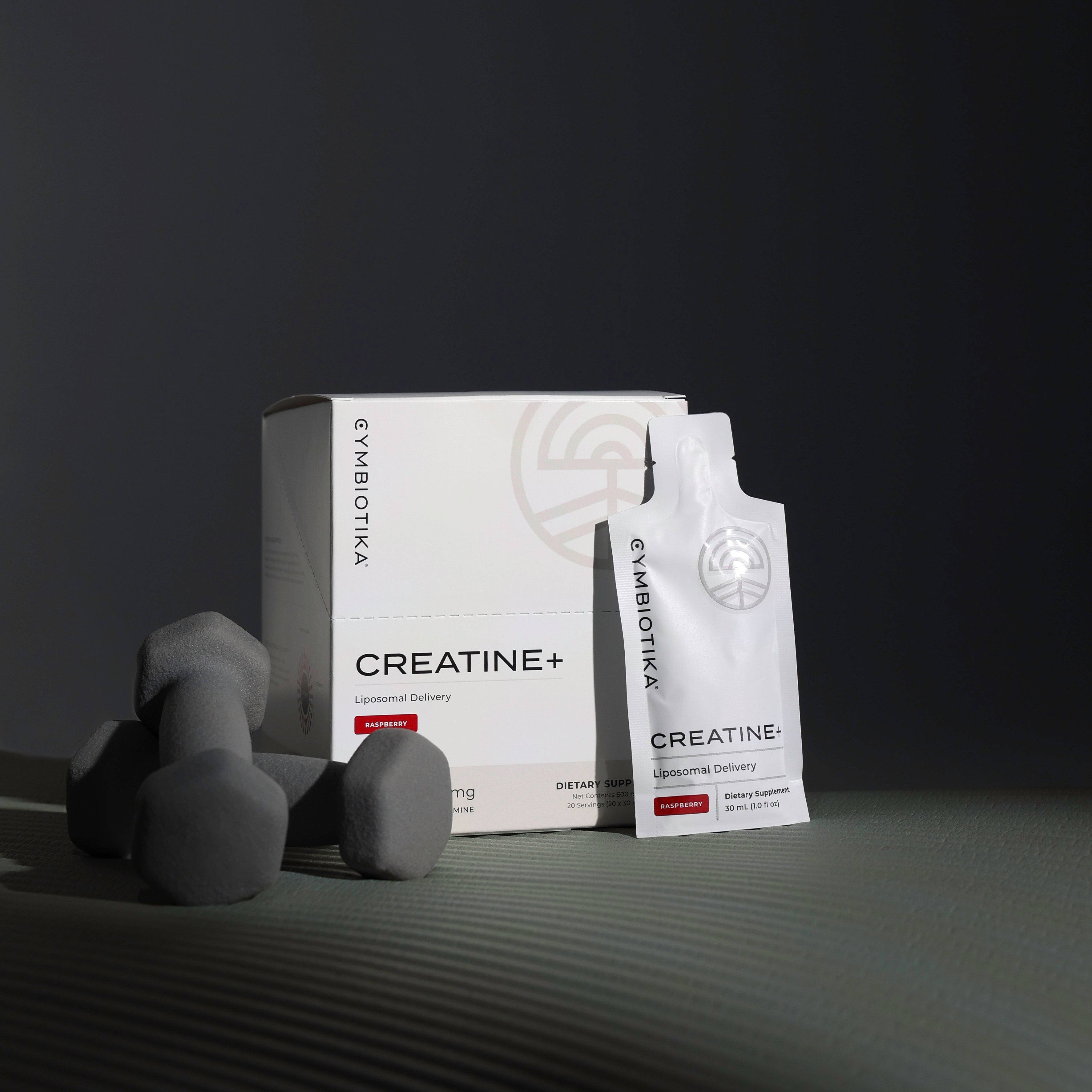 Creatine+ Box with Creatine+ pouch next to exercise weights