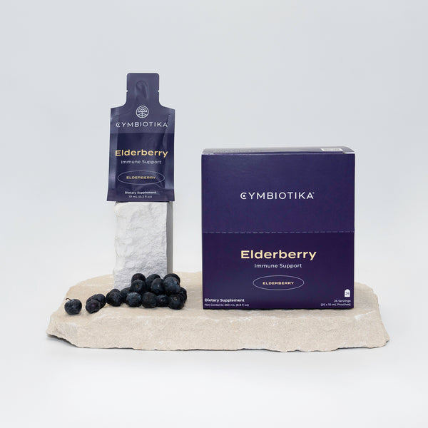 Liposomal Elderberry On Stone Next to Elderberries 