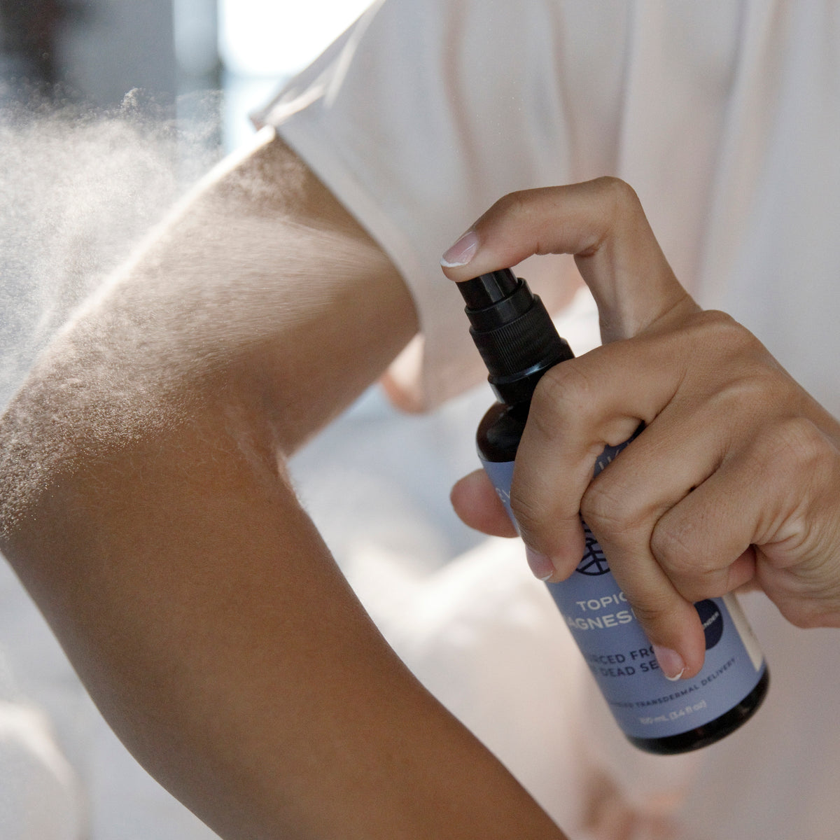 Topical Magnesium Oil Spray Being Sprayed onto Arm